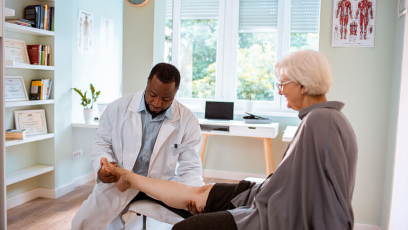 Senior woman having physical therapy in the doctors office for pain management