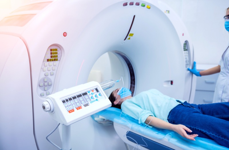 Radiologist with a female patient in the room of computed tomography