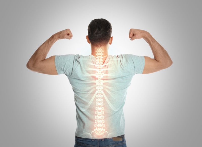 Man with healthy back on light background. Spine pain prevention