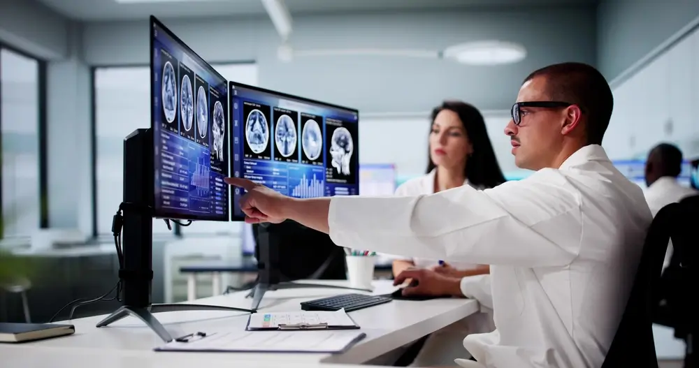 Doctors In Clinic Looking At Brain MRI Scan.