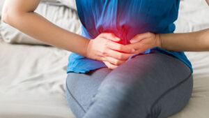 Abdominal pain in woman with stomachache illness from menstruation cramps, stomach cancer, irritable bowel syndrome, pelvic discomfort, Indigestion, Diarrhea or GERD (gastro-esophageal reflux disease)