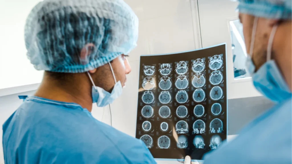 back view of doctors in uniforms and medical masks looking at x-ray