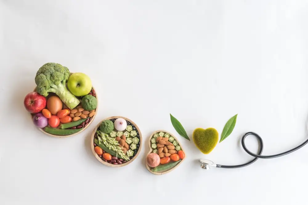 Organic healthy food in wooden bowls,medical stethoscope and green heart shape on white background for the health concept.